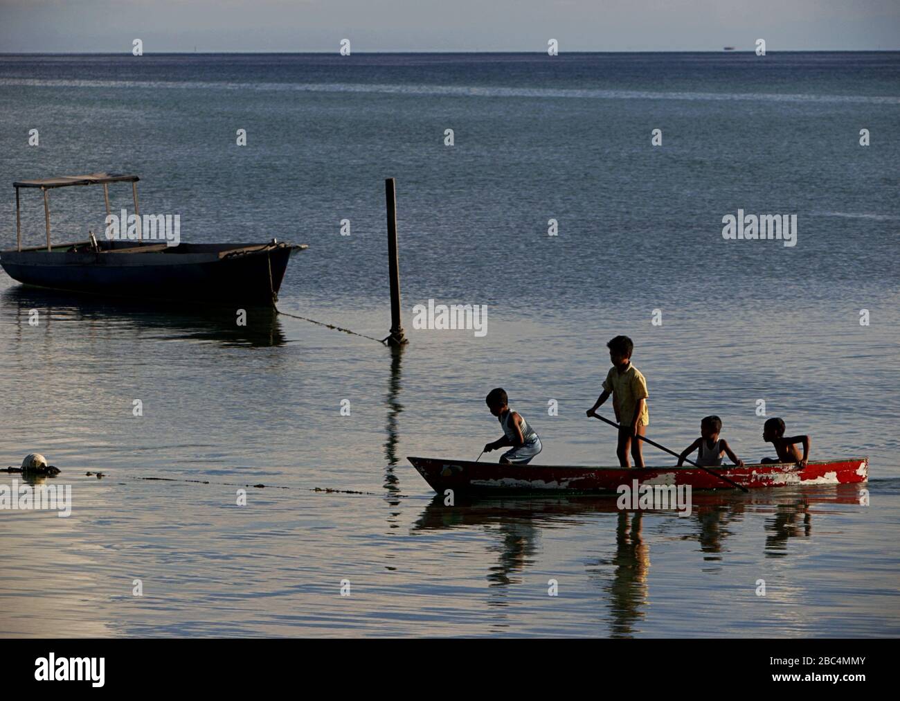 Children boating on coastal water off Derawan Island, a part of Berau Marine Protected Area in Berau, East Kalimantan, Indonesia. Stock Photo