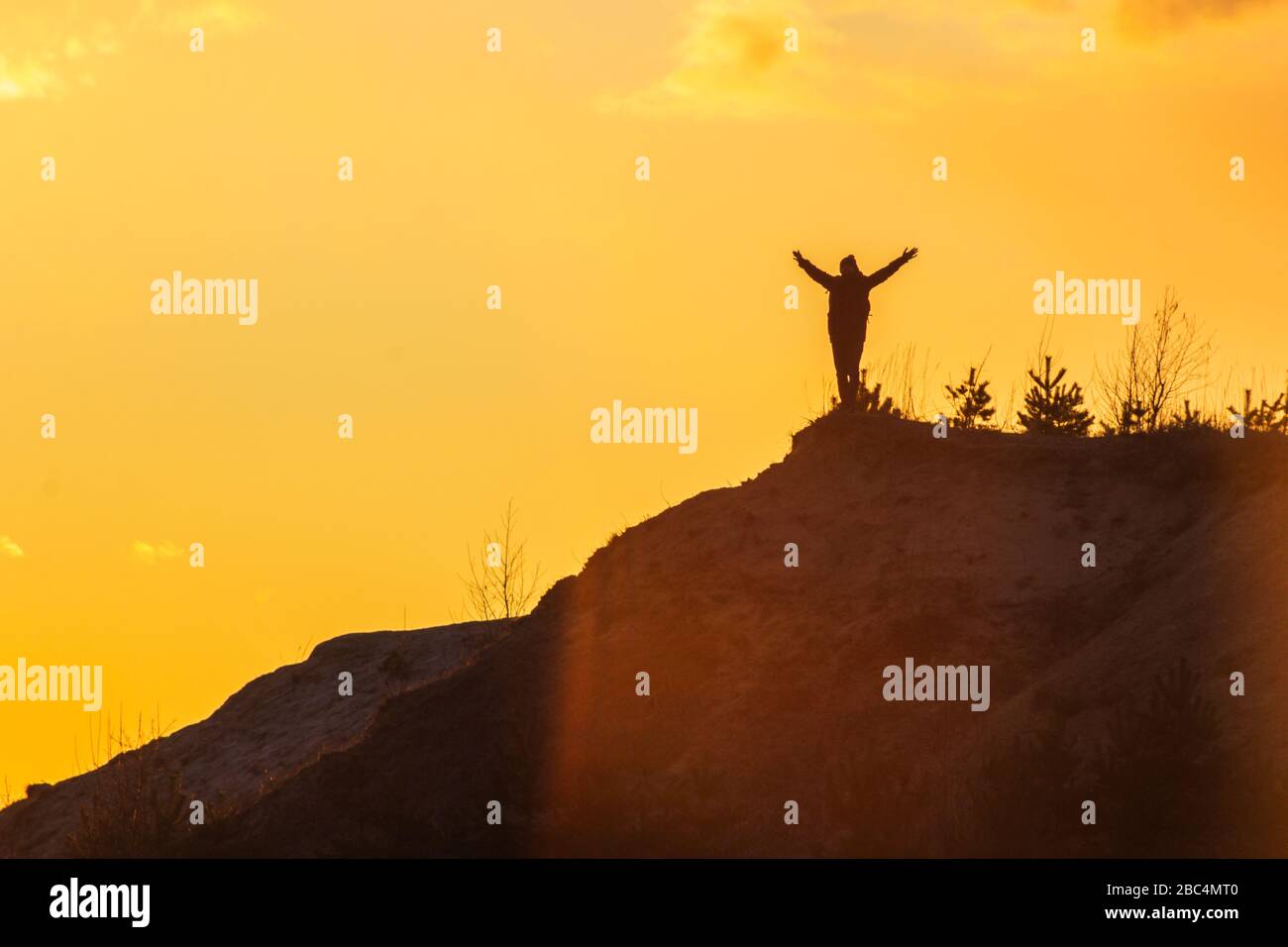 man at the top of the mountain at sunset success Stock Photo - Alamy