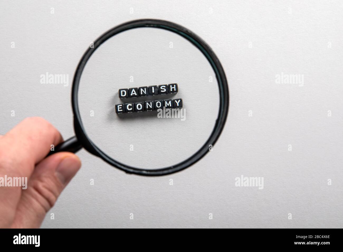 Danish Economy Man S Hand Holding Magnifying Glass Imports And Exports Growth Planning And Reporting National Budget Concept Stock Photo Alamy