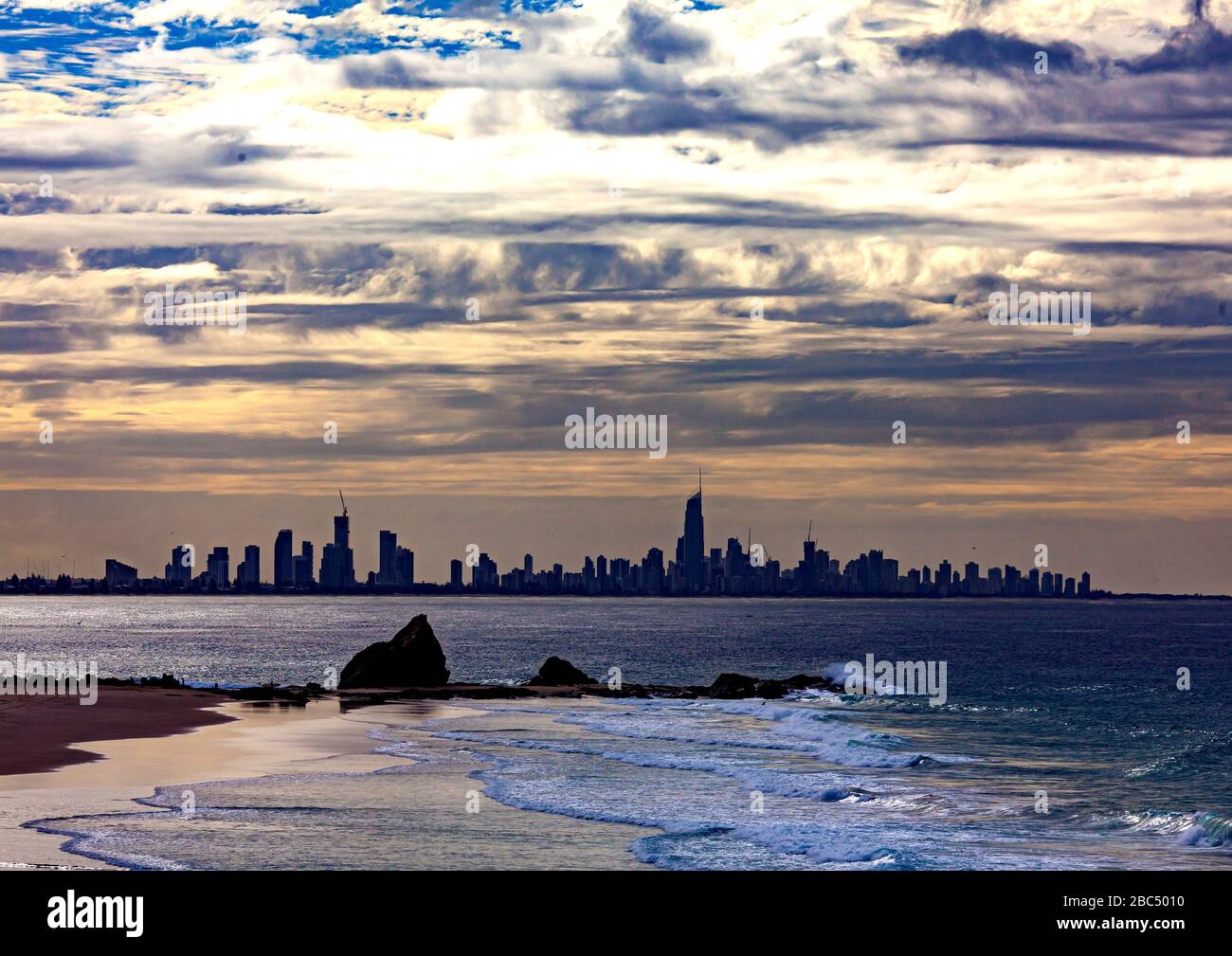 Surfers Paradise with dramatic clouds seen across the Coral Sea from Tugan Beach in the Australian state of Queensland Stock Photo