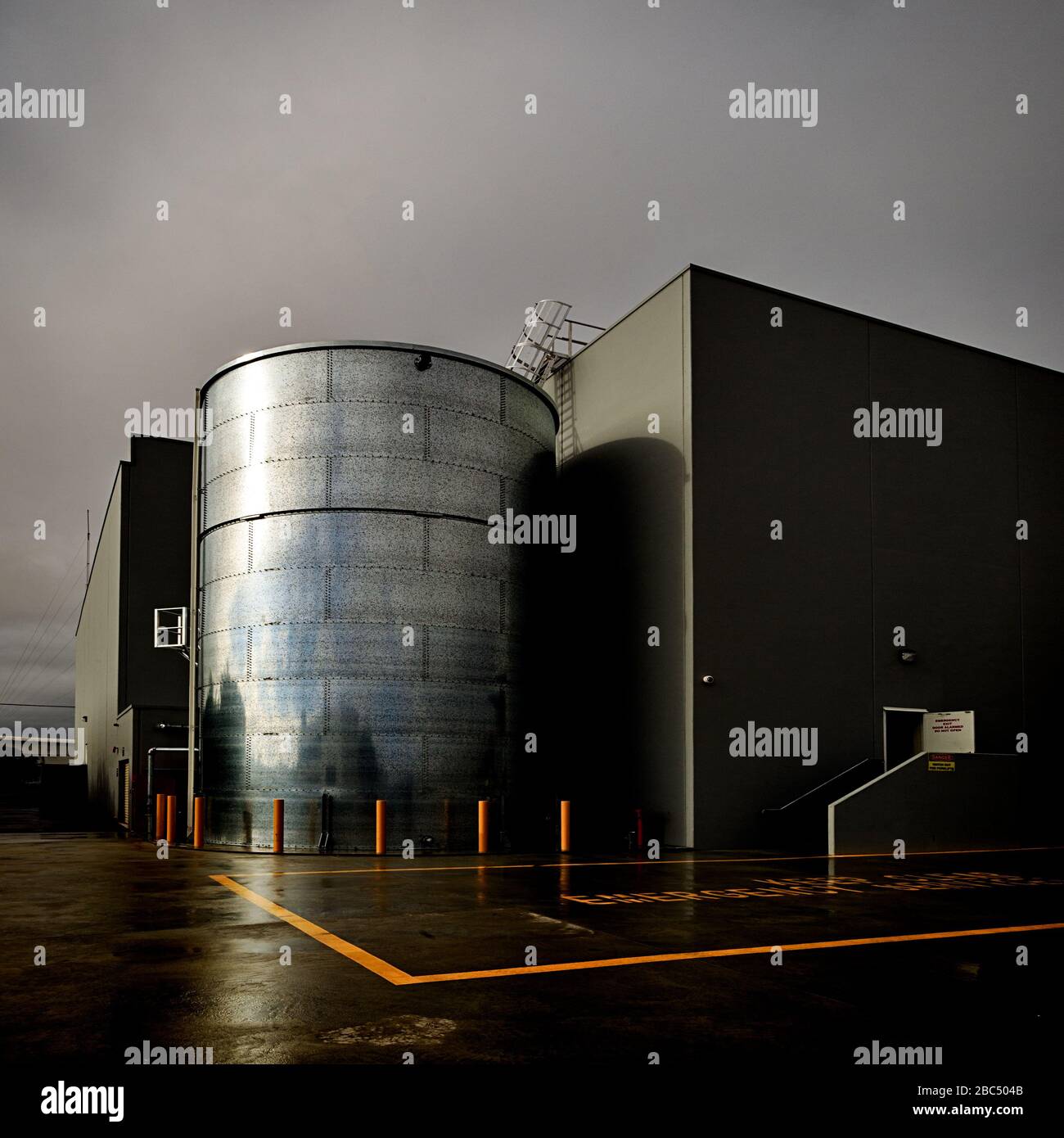 Steel water tank in industrial setting on a rainy day Stock Photo
