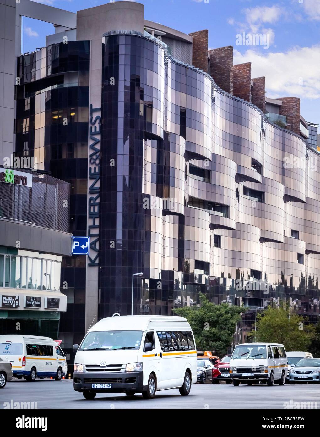 Johannesburg, South Africa 18th February - 2020: Minibus taxis passing by modern corporate office buildings. Stock Photo
