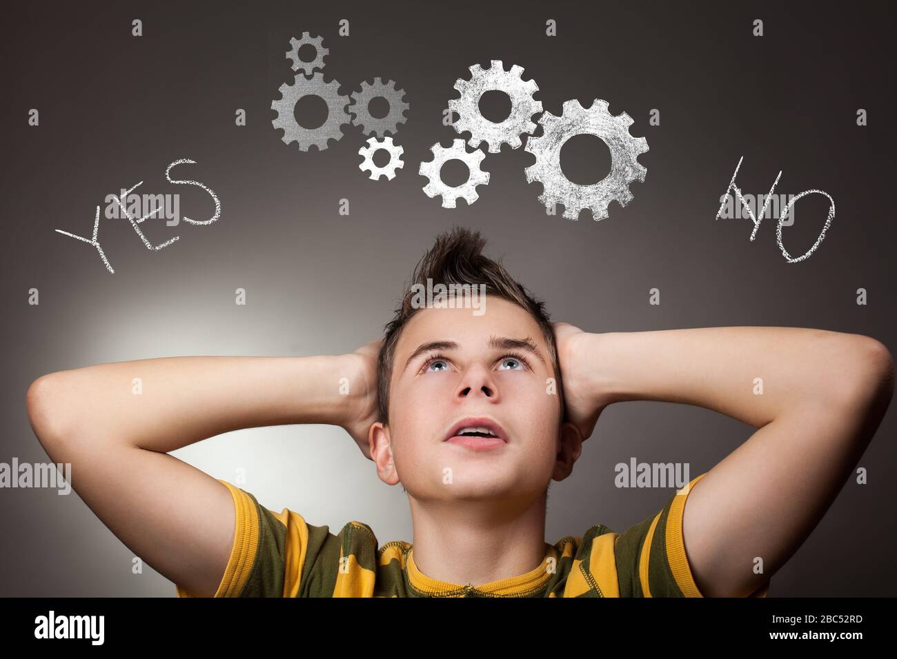 Young boy looking up at Yes and No words Stock Photo