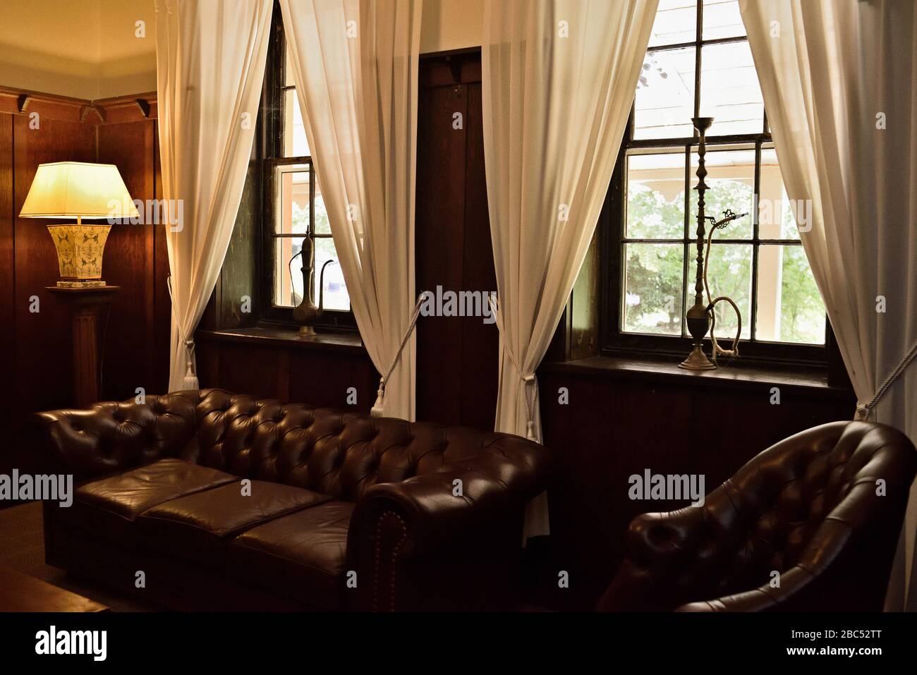 Cigar, smoking room, chesterfield couch, hookah water pipes, ceramic chinese lamp, historic country house and hotel, Southern Highlands , Australia Stock Photo