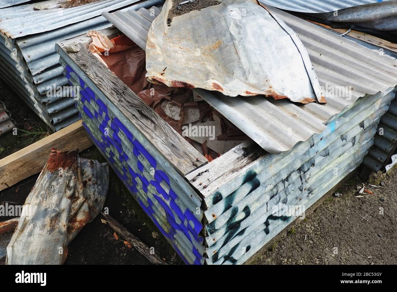 Asbestos from industrial site cleansing & remediation, hazardous material stored on-site in makeshift corrugated iron cases at The Maltings, OH&S, NSW Stock Photo
