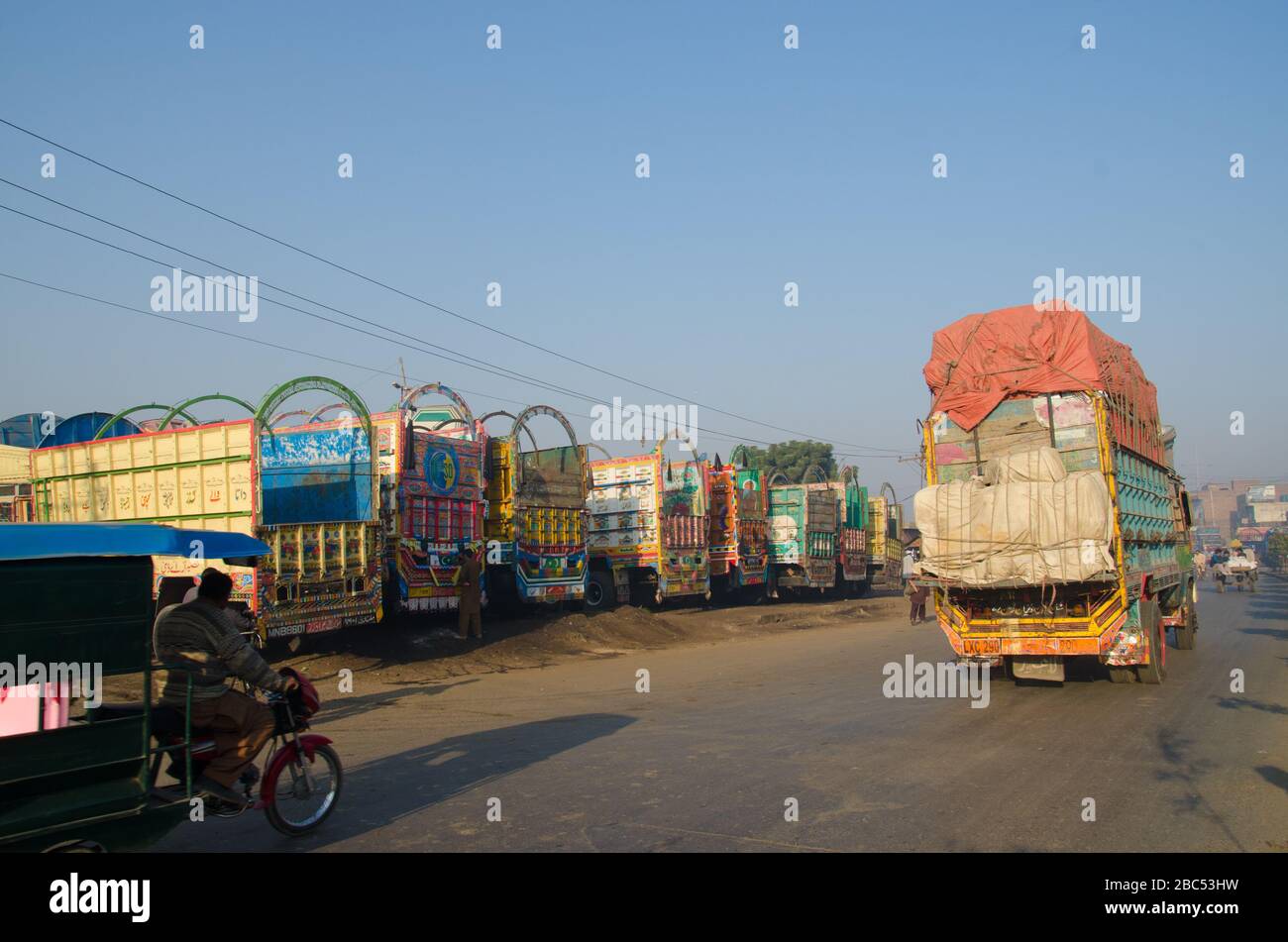 A truck passes by a row of transport trucks in fruits & vegetable
