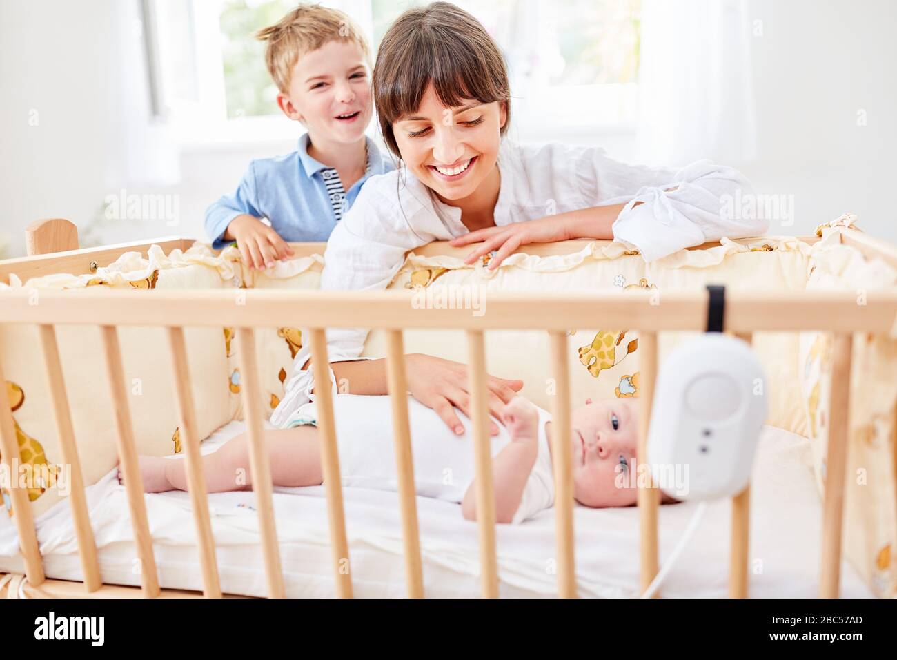 Mother with child caresses baby in cot before falling asleep Stock Photo
