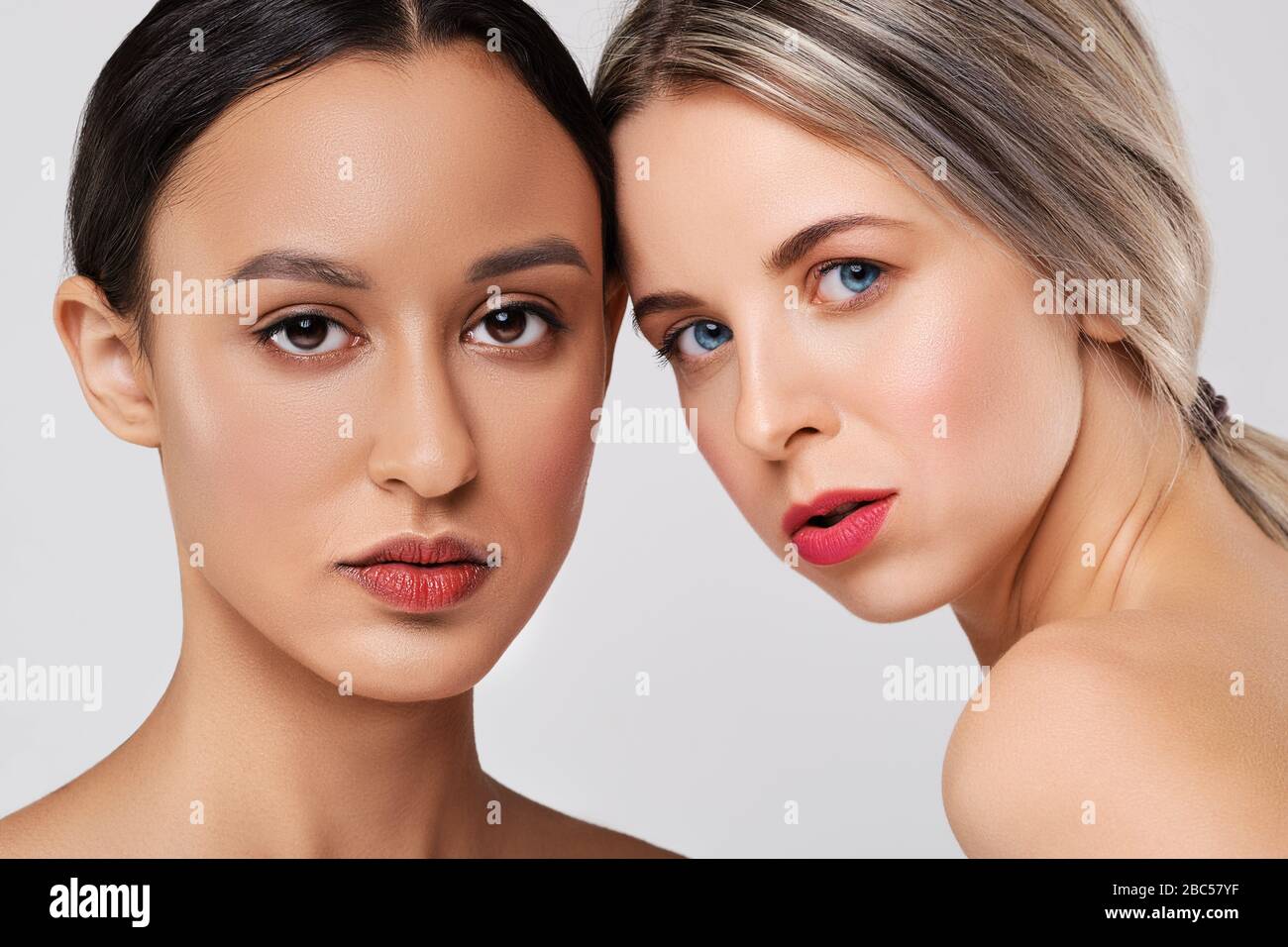 Close up portrait of beautiful caucasian and african girl models with different types of skin. Stock Photo
