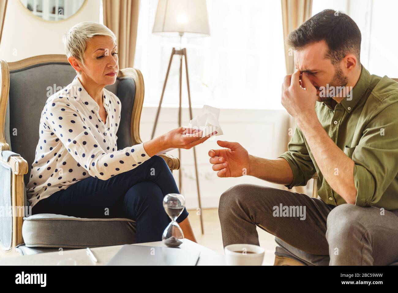Frustrated man sitting in his psychoanalysts office Stock Photo
