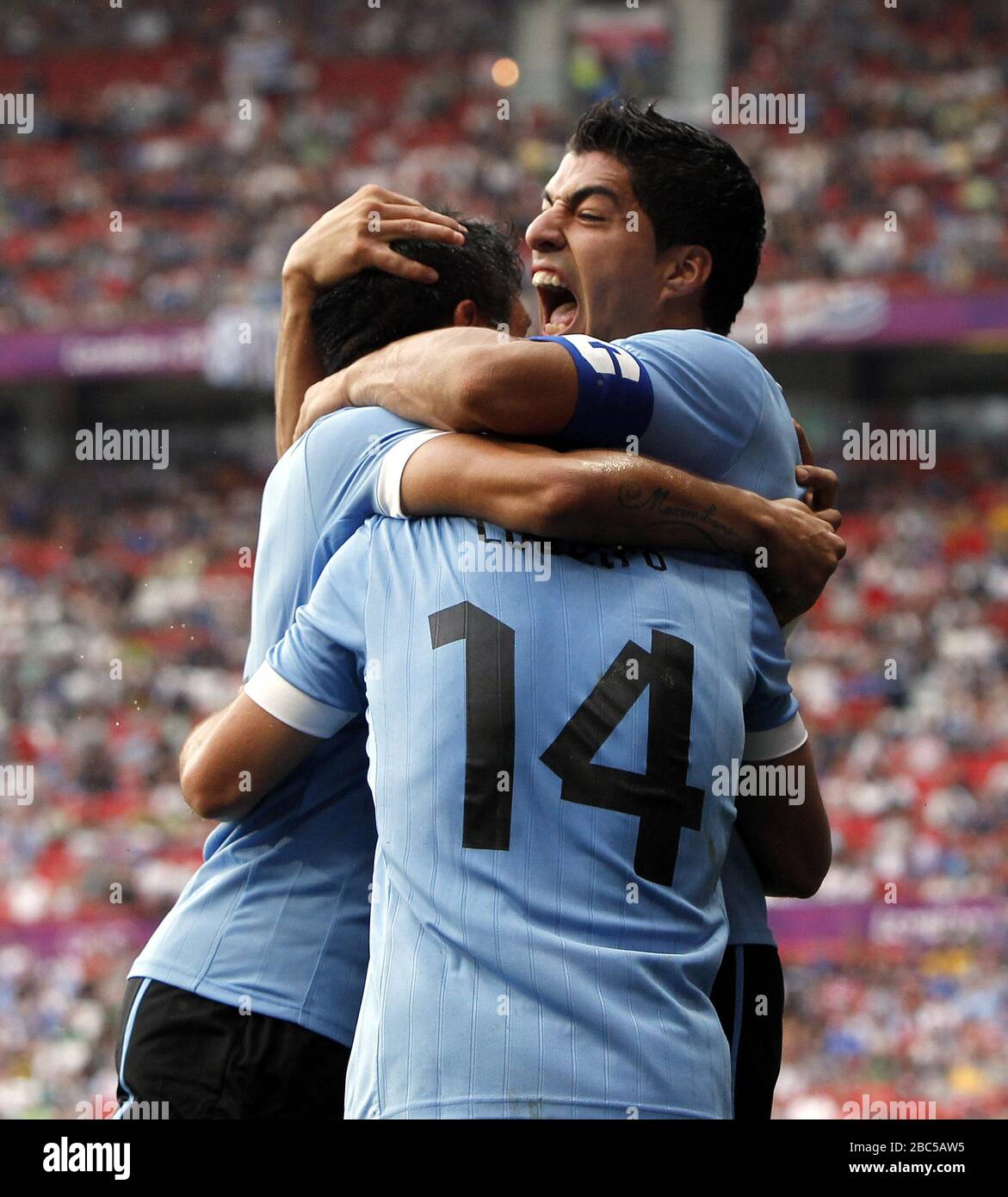 Uruguay's Luis Suarez (centre) celebrates with goal scorer Nicolas Lodeiro (14) and Ramon Arias (left) during the UAE v Uruguay, Mens Football, First Round, Group A match at Old Trafford, Manchester. Stock Photo