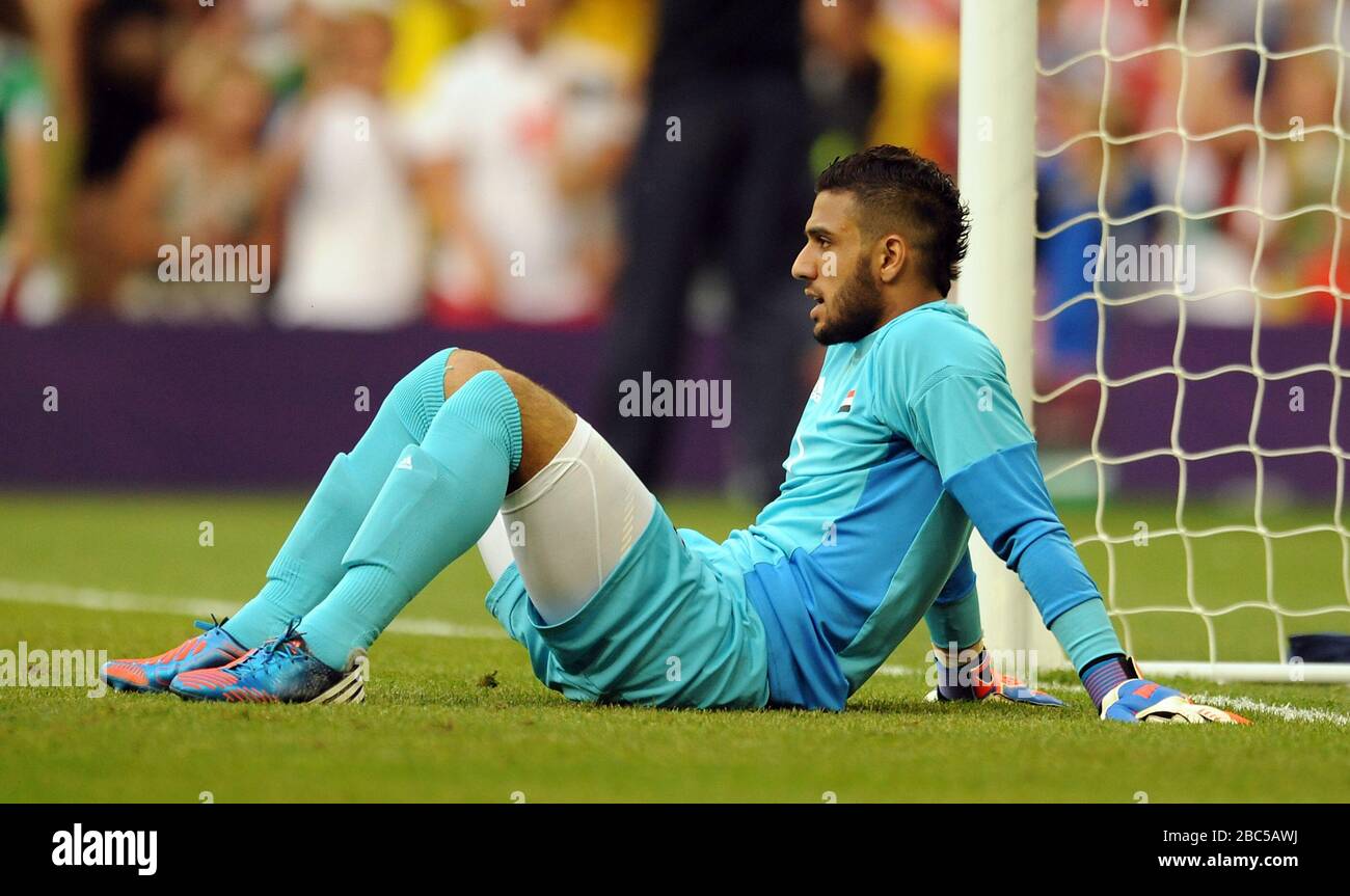 Egypt goalkeeper Ahmed Elshenawi sits dejected on the floor after his side concede a third goal to Brazil's Neymar (not pictured) during the Brazil v Egypt, Mens Football, First Round, Group C match at the Millennium Stadium, Cardiff. Stock Photo