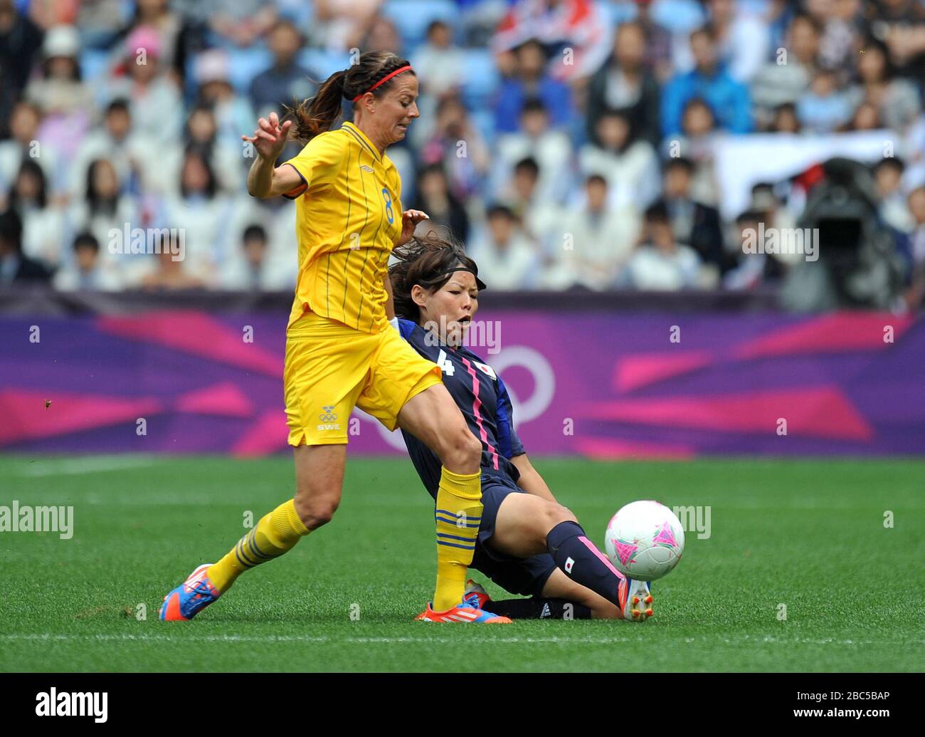Japan's Saki Kumagai tackles Sweden's Lotta Schelin (left) during the Group F women's match at the City of Coventry Stadium. Stock Photo