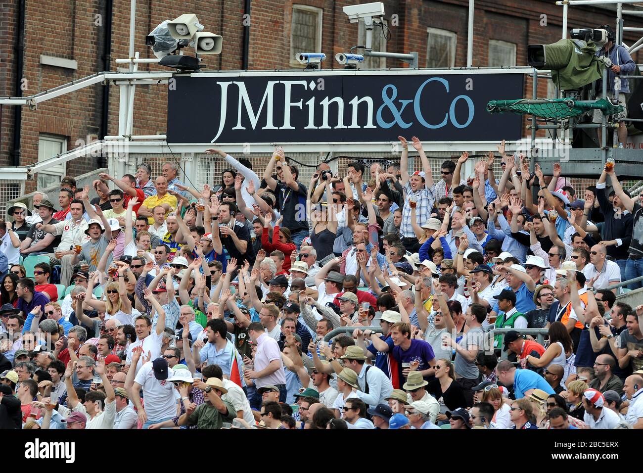 Fans enjoy a Mexican wave in the stands Stock Photo