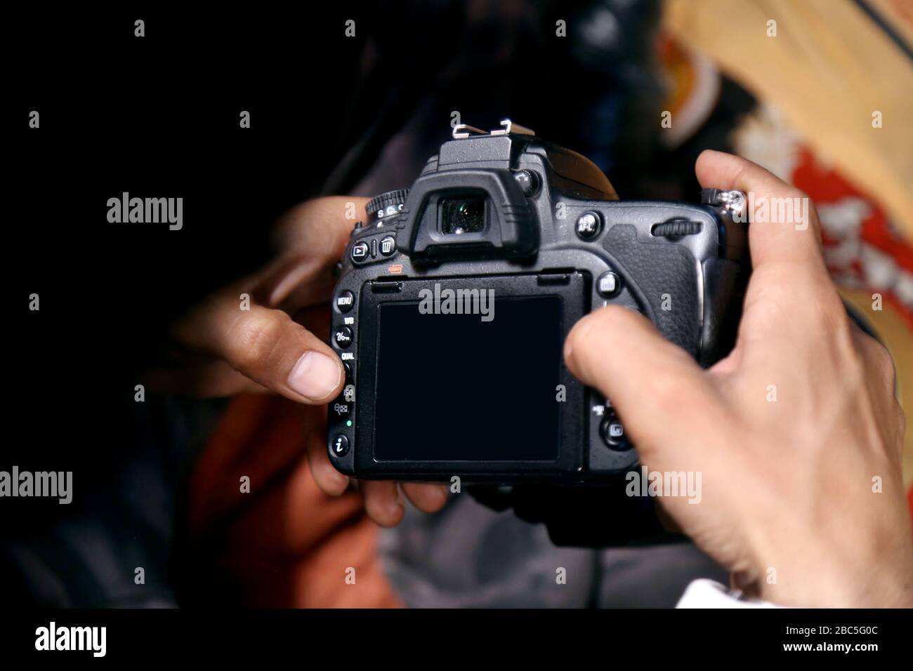 Man in suit taking photo. Photography concept.The photographer hold DSRL camera in his hands with shine white blur background indoors in studio or wed Stock Photo