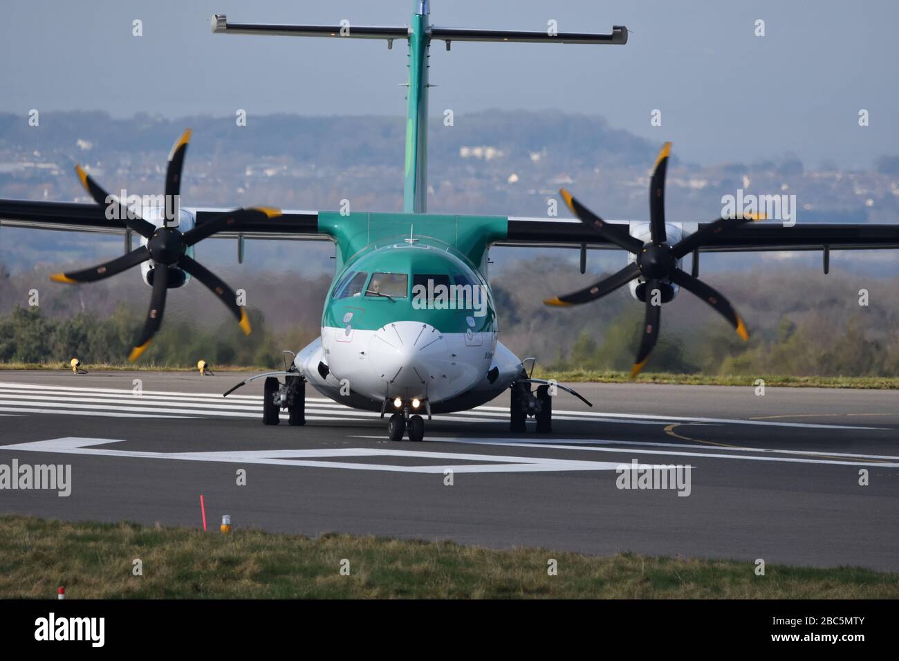 A small Aer Lingus airline propeller plane at Bristol International Airport about to take off on the runway Stock Photo