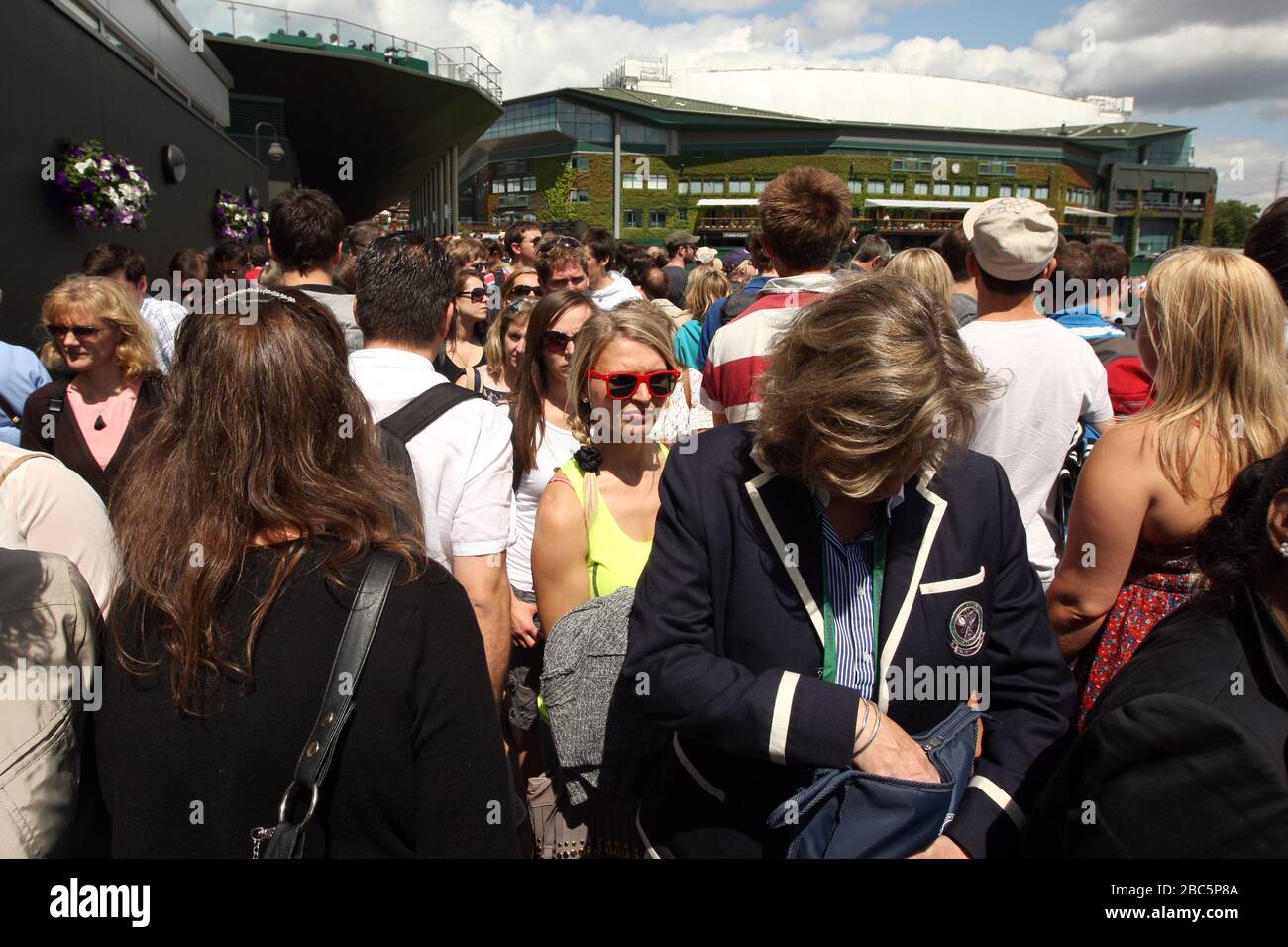 Packed crowds mill around the outside courts at Wimbledon Stock Photo