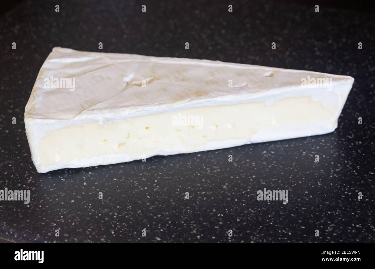 Brie cheese cut in the shape of triangle Stock Photo Alamy