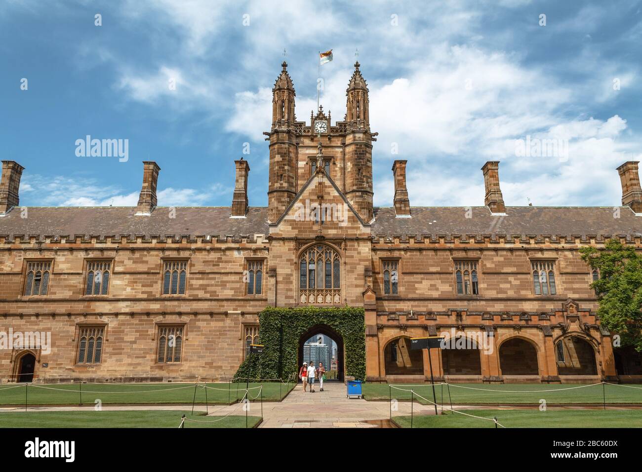 People standing beneath the University of Sydney Quadrangle Clocktower on a summer afternoon Stock Photo