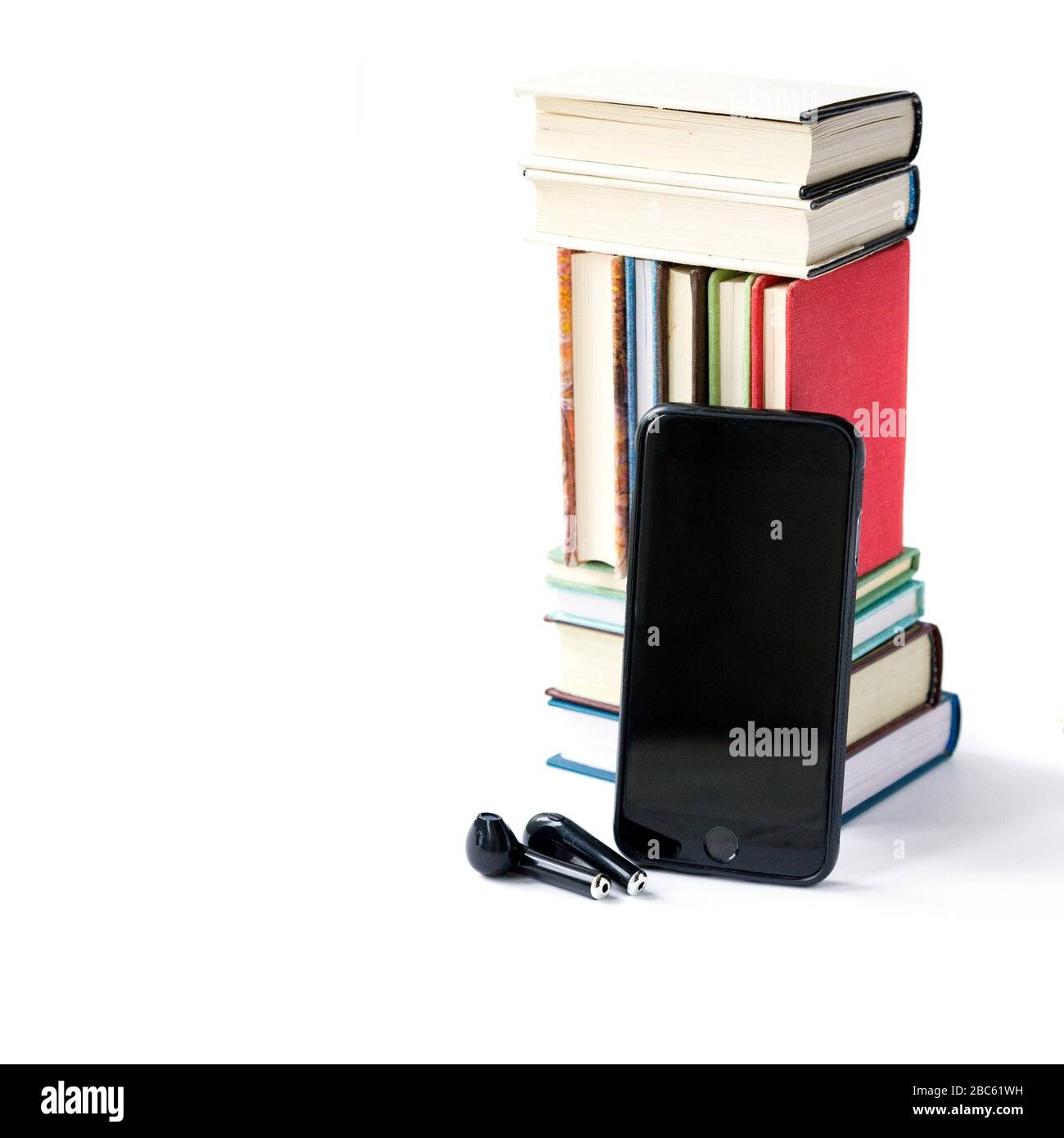 Stack of colored books, headphones and mobile phone, Mobile library in smartphone concept, audiobooks, Listening to e-books in audio format. Books onl Stock Photo