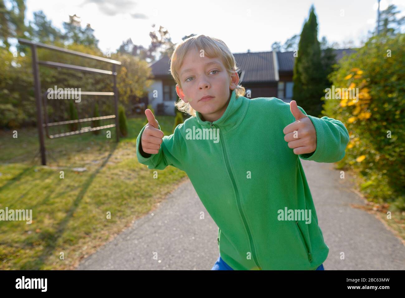 Young handsome boy giving thumbs up in the front yard Stock Photo - Alamy