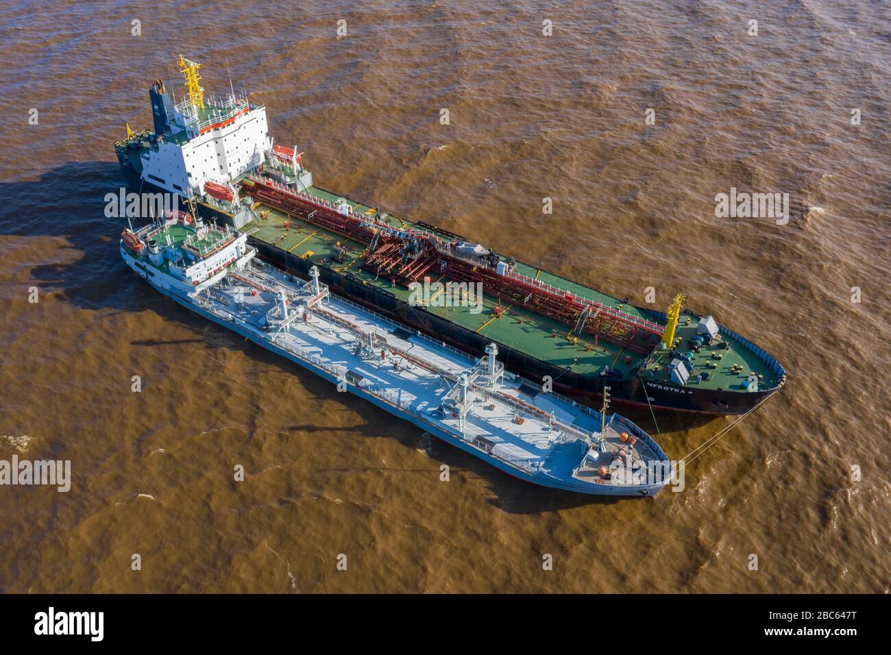 The tankers Chukotka + and Lenaneft 2033 are moored to each other, overload oil products. Stock Photo