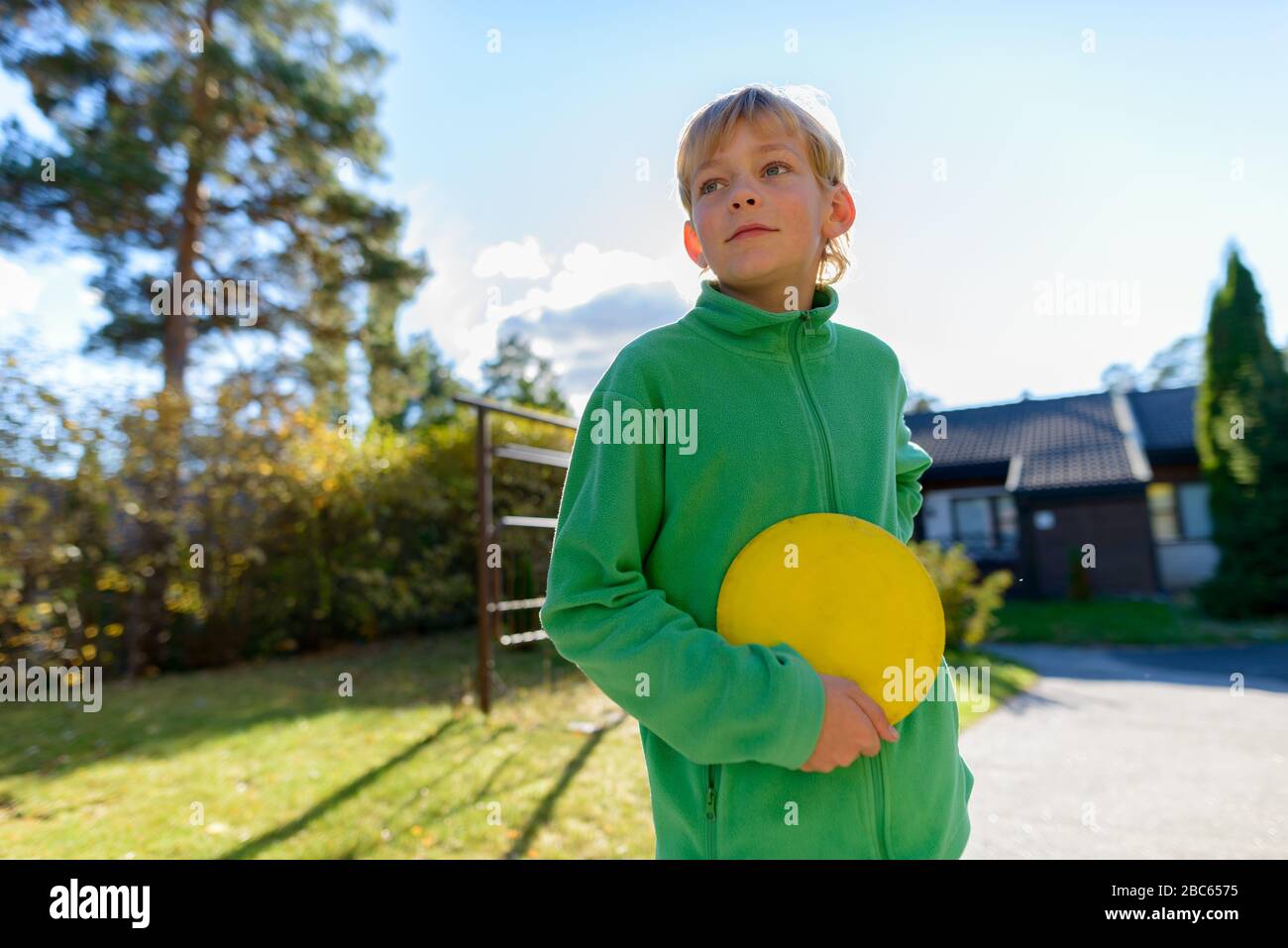 Young handsome boy playing Frisbee in the front yard Stock Photo