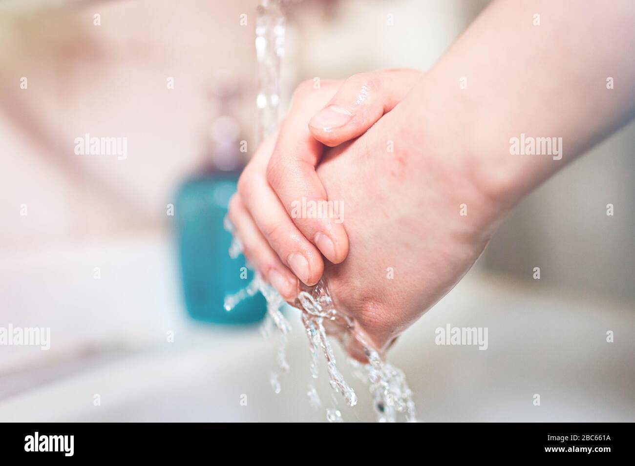 Washing hands under running water using soap, important step for a good