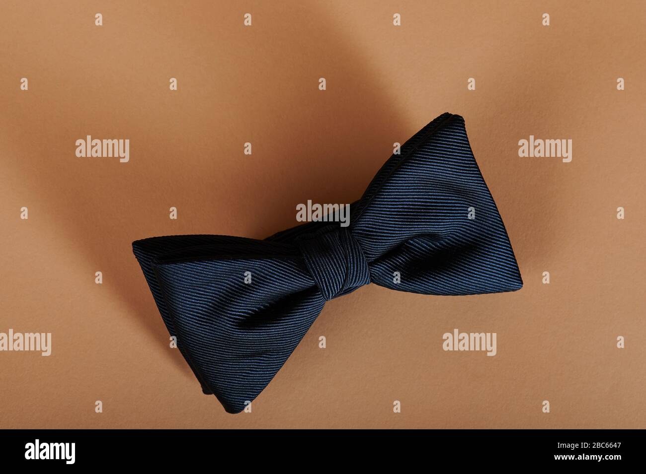 Blue neck bow tie on beige color background above top view Stock Photo