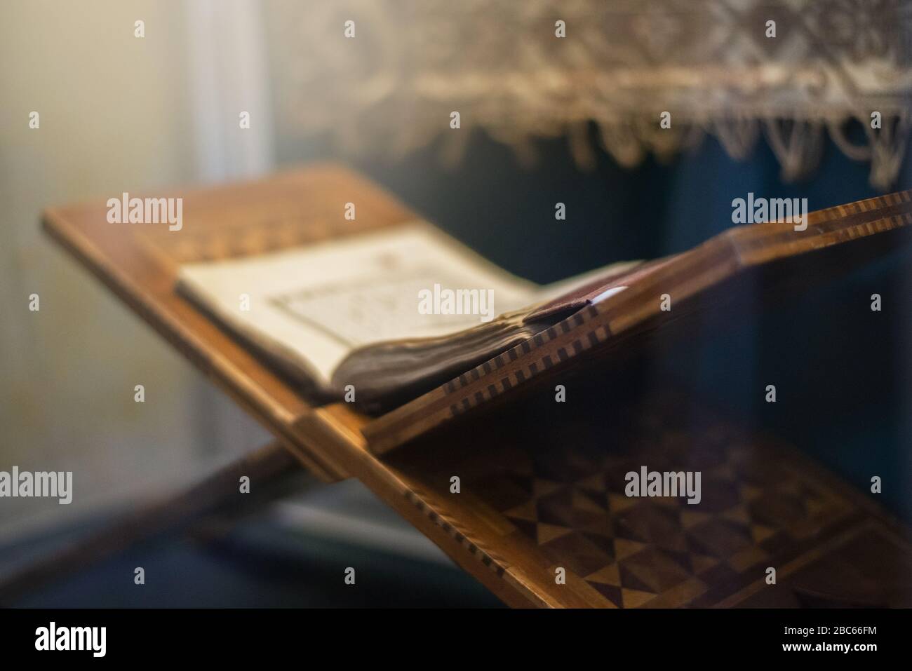 Quran islamic holy book on dark background with with blurred traditional carpet for reading in ramadan night, muslim style and ramadan concept Stock Photo