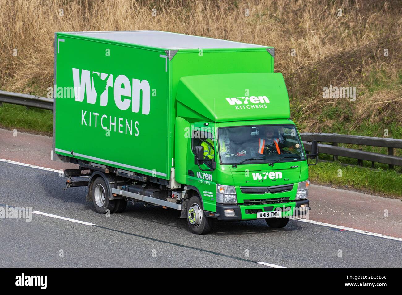 Wren Kitchens Haulage delivery trucks, green Mitsubishi Fuso Canter 7c18 38 Auto lorry, transportation, truck, cargo carrier, vehicle, European commercial transport, industry, M6 at Manchester, UK Stock Photo