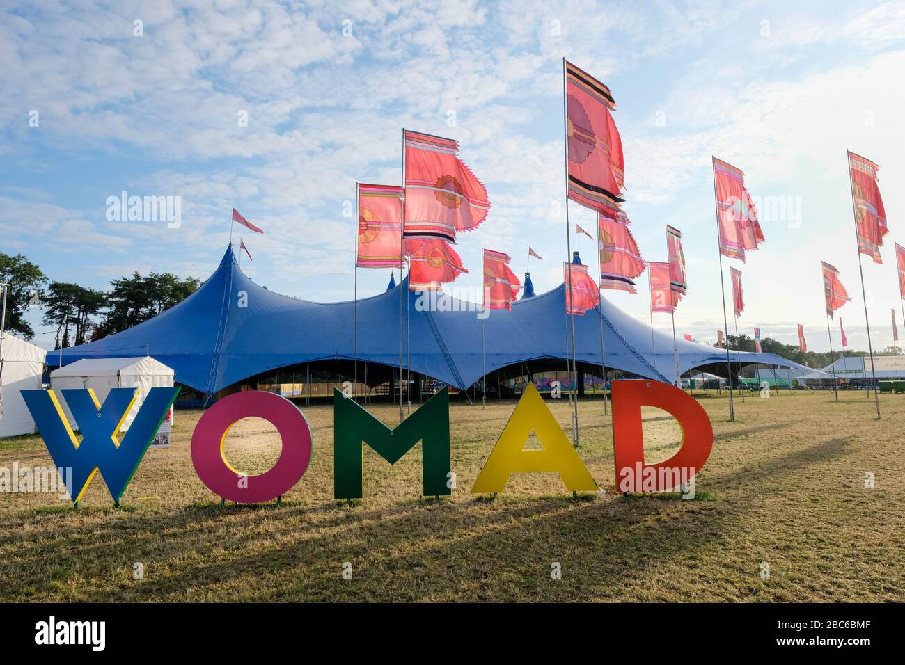 Multicoloured WOMAD sign, (World of Music and Dance) outside the Siam tent at the festival site, Charlton Park, UK. July 28, 2019 Stock Photo