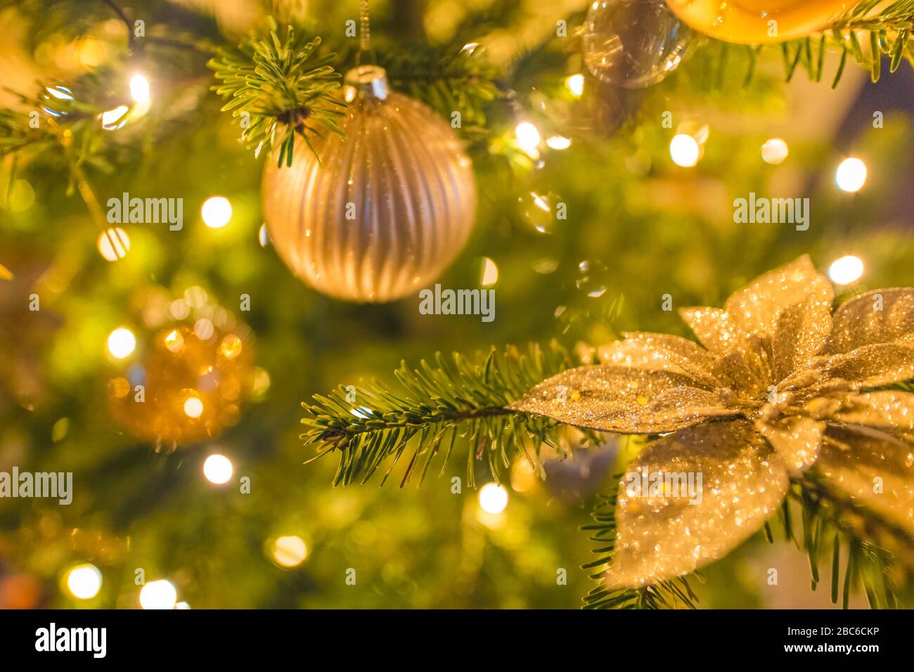 Decorated Christmas tree on blurred background. Holiday closeup, golden decoration Stock Photo