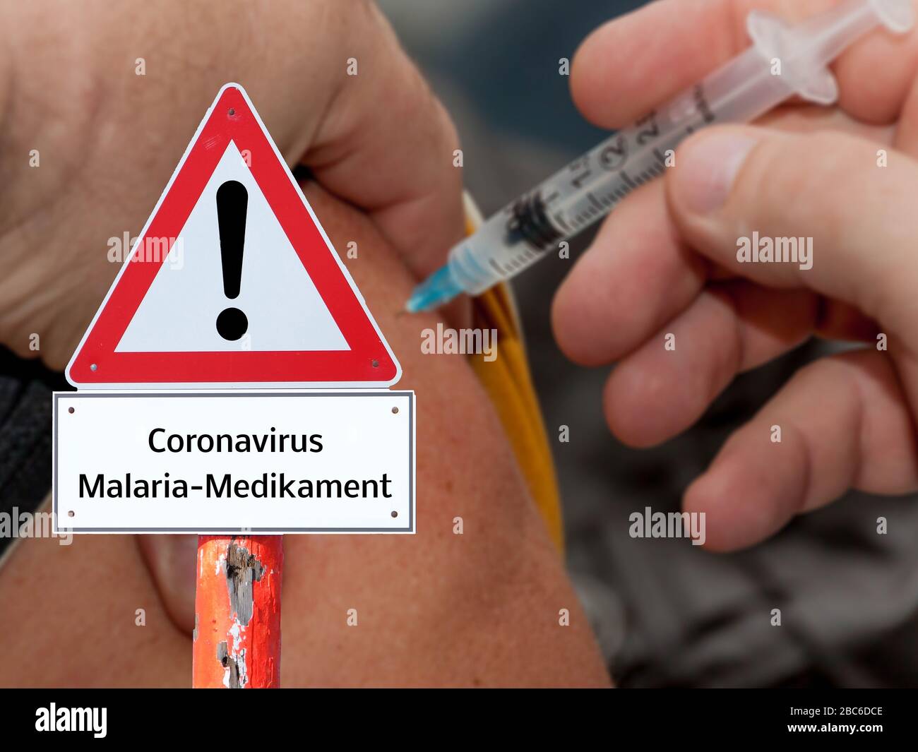 Warning sign Coronavirus malaria drug in german Stock Photo
