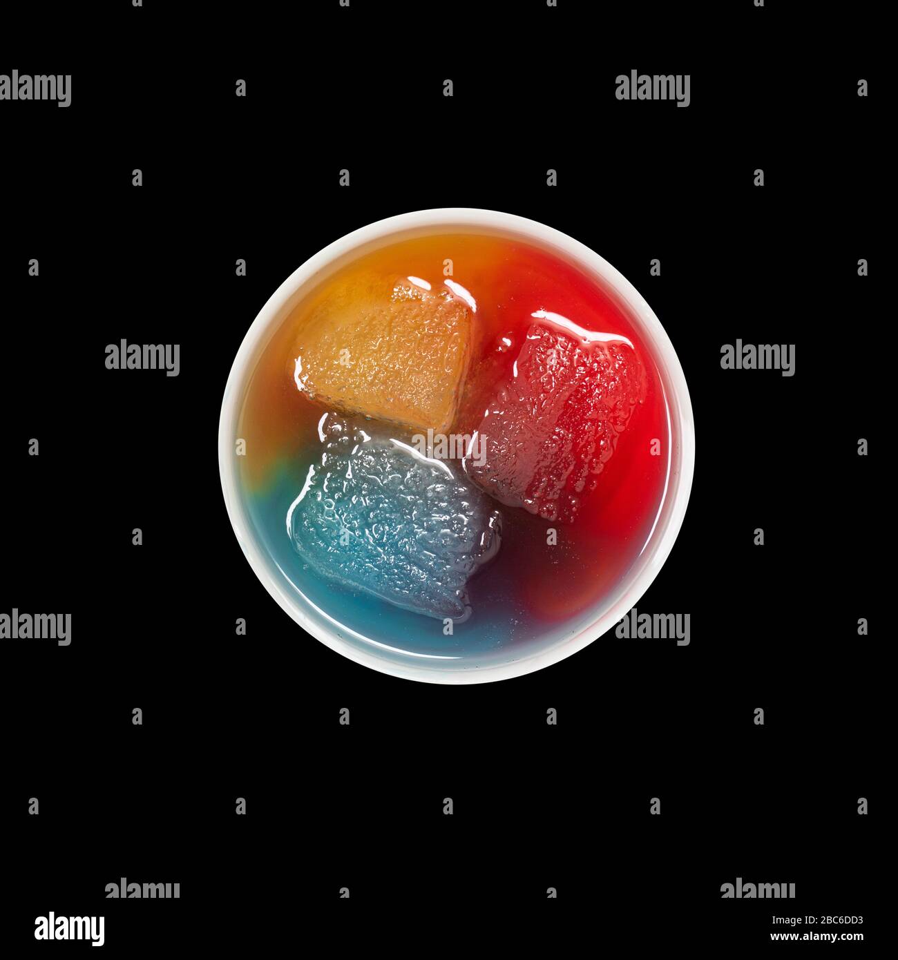 Top view of bowl with ice melting in primary colors on black Stock Photo