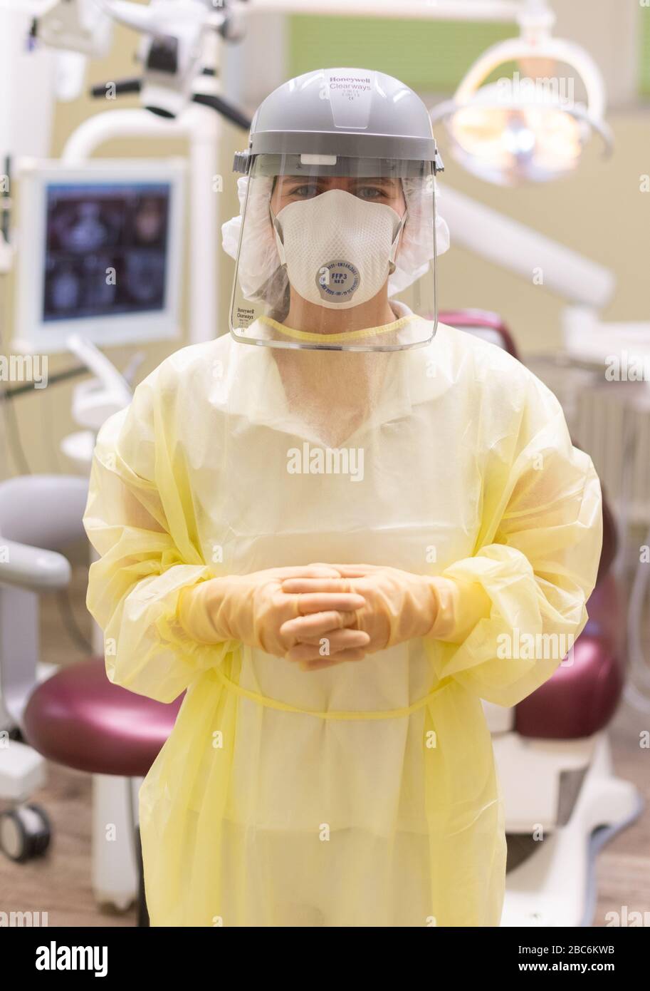 Dresden, Germany. 03rd Apr, 2020. Anja Biedermann, 2nd year trainee as a dental assistant, is standing in a dental practice, which also treats corona patients, with a protective visor, FFP3 respiratory mask and an antiviral gown in a treatment room. Credit: Robert Michael/dpa-Zentralbild/dpa/Alamy Live News Stock Photo