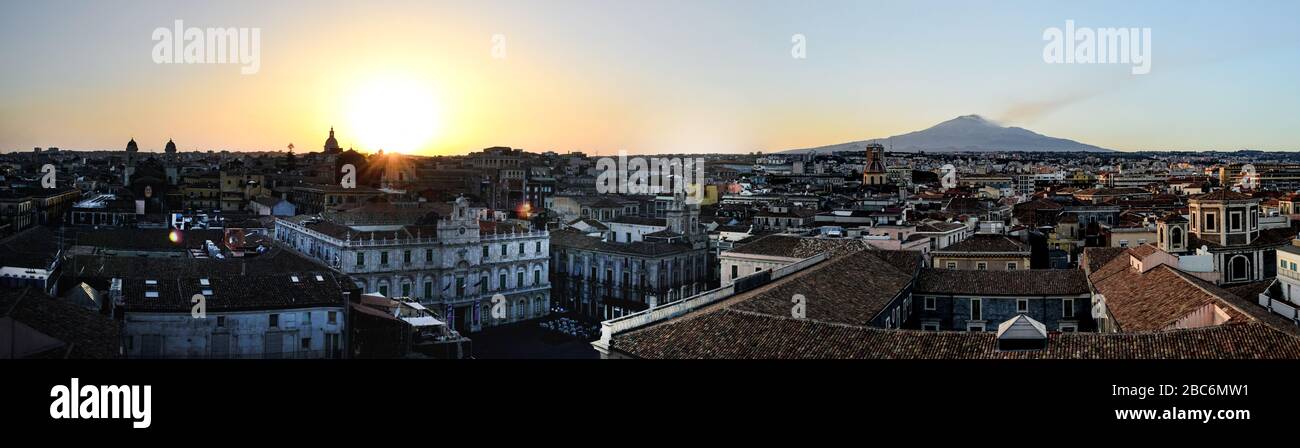 Catania, Sicily in Italy. Aerial view of the city roofs at sunset with the incredible Etna vulcano smoking in the background, nice warm colors Stock Photo