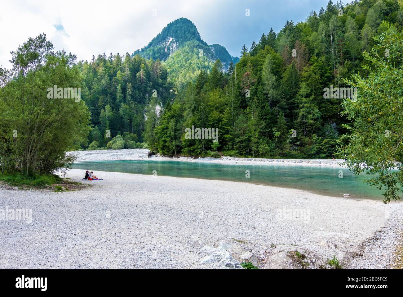 Triglav, Slovenia - August 11, 2019: Girls Hikers have a rest on the river bank in Triglav national park. Julian Alps, Triglav, Slovenia Stock Photo