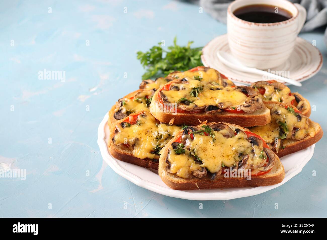 Hot sandwiches with tomatoes, champignons, cheese and cup of coffee on ...