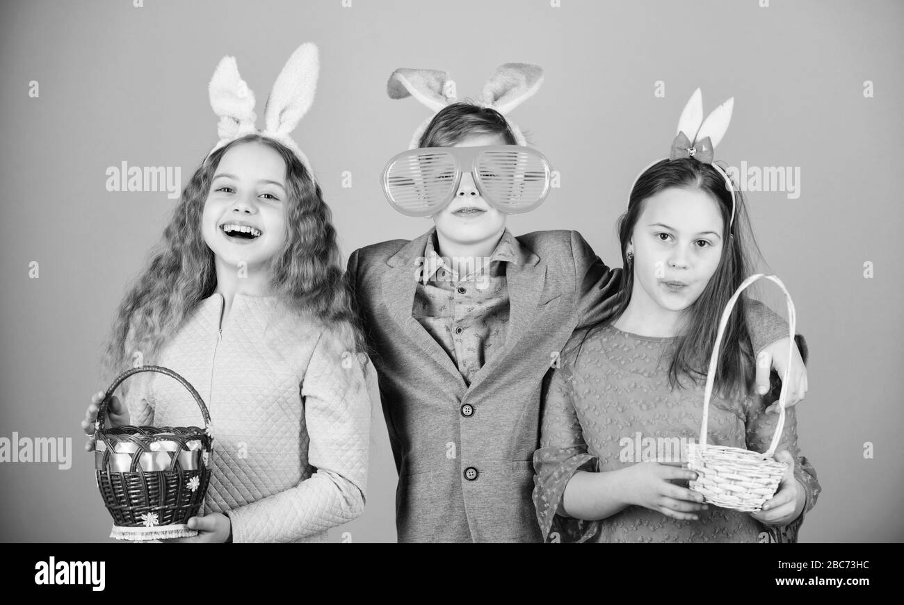 Egg hunt. Family and sisterhood. Spring holiday party. Little girls and boy with busket. Happy easter. Children in rabbit bunny ears. easter hunt. Collecting Easter eggs. Egg hunt play. Feel excited. Stock Photo