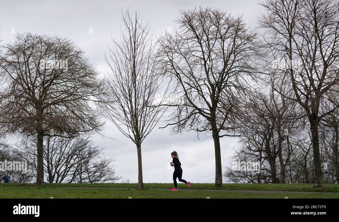 Glasgow, Scotland, UK. 3 April, 2020. Images from the southside of Glasgow at the end of the second week of Coronavirus lockdown. Pictured woman running alone in Queens Park.  Iain Masterton/Alamy Live News Stock Photo