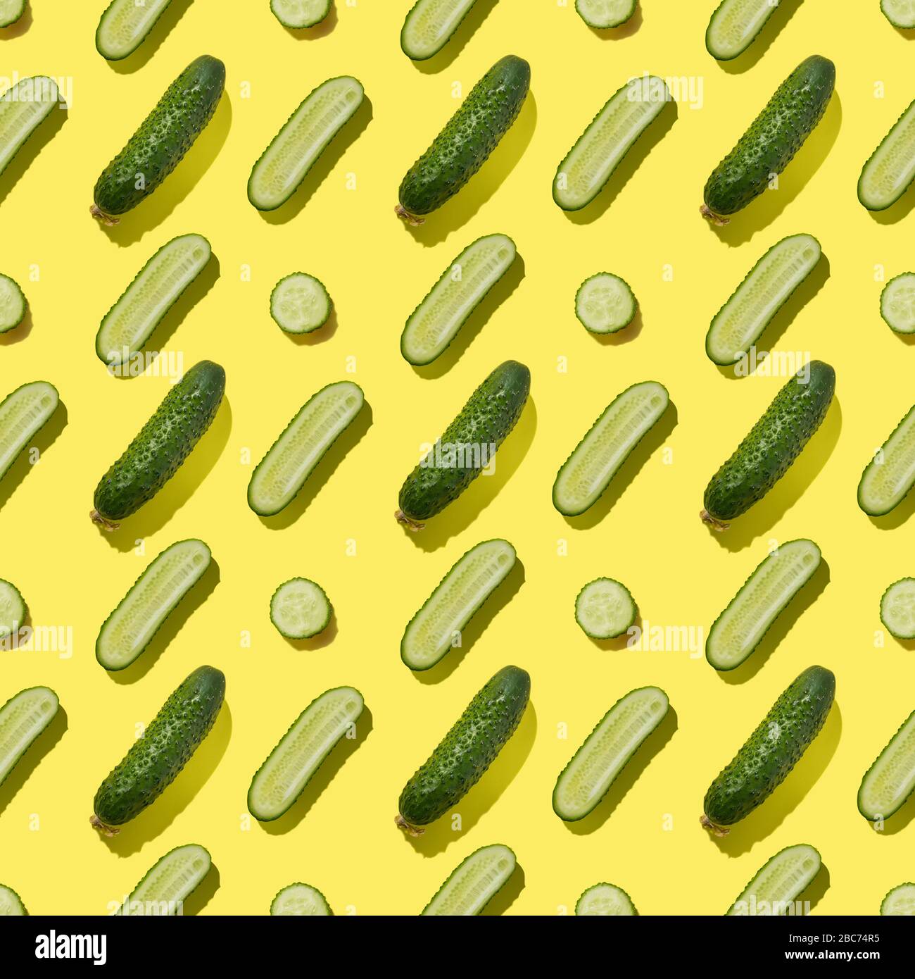 Seamless pattern of cucumbers on yellow background. Flat lay, Food vegetables texture. Stock Photo
