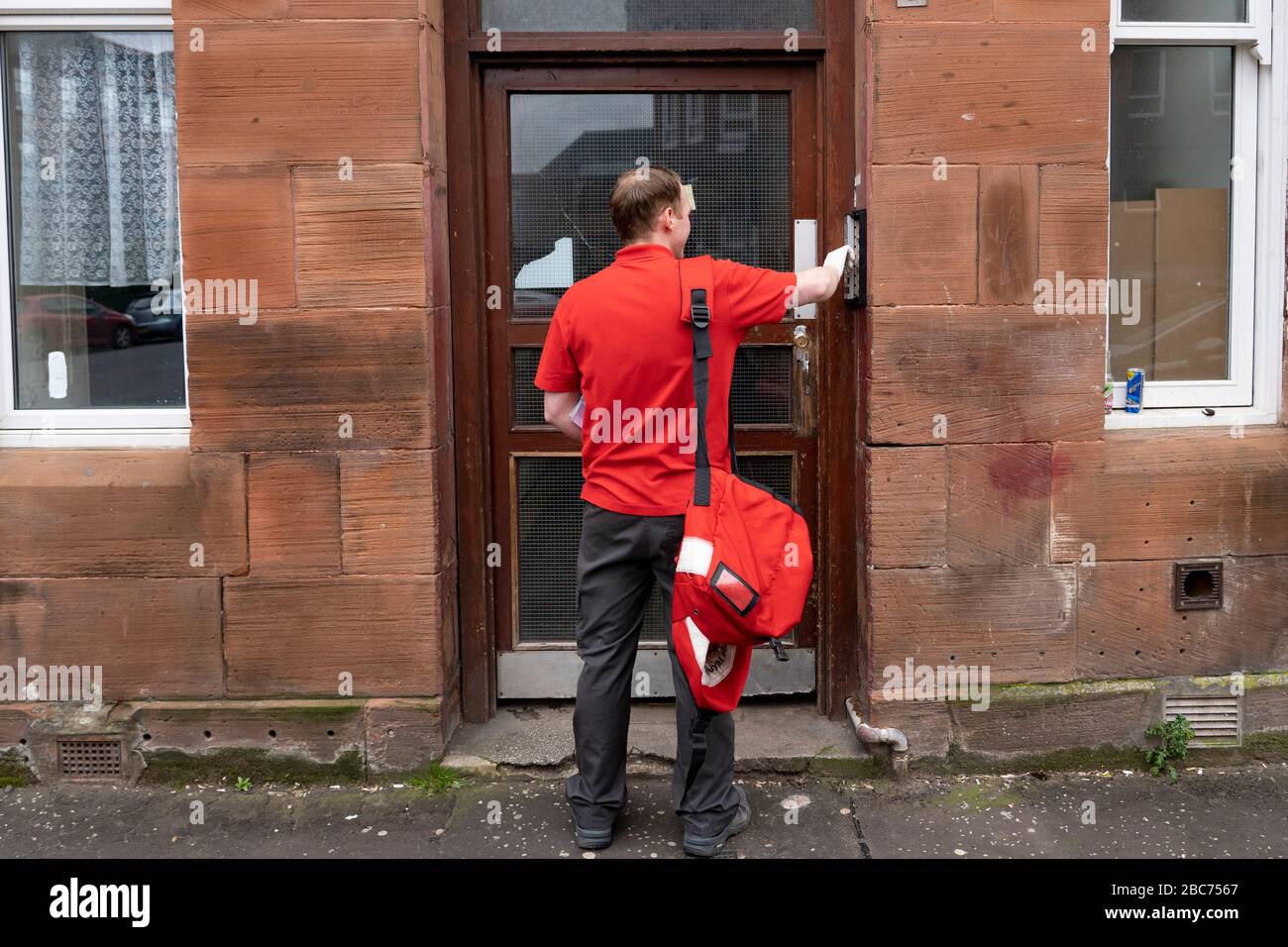 Glasgow, Scotland, UK. 3 April, 2020. Images from the southside of Glasgow at the end of the second week of Coronavirus lockdown. Pictured; Royal Mail postman making deliveries to tenement in Govanhill . Iain Masterton/Alamy Live News Stock Photo