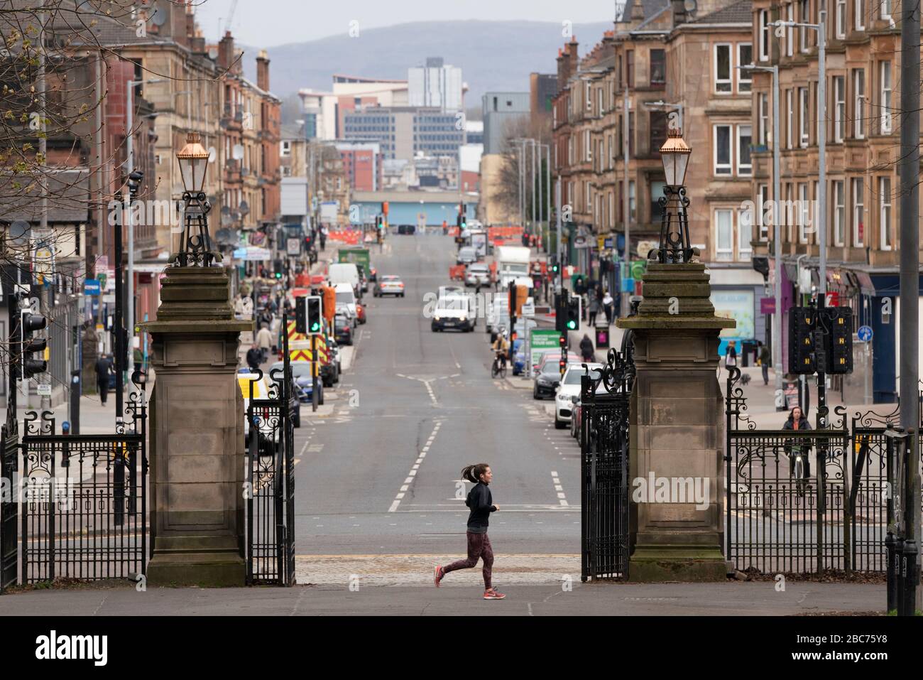 Glasgow, Scotland, UK. 3 April, 2020. Images from the southside of Glasgow at the end of the second week of Coronavirus lockdown.  Jogger runs past a very quiet Victoria Road in Govanhill.  Iain Masterton/Alamy Live News Stock Photo