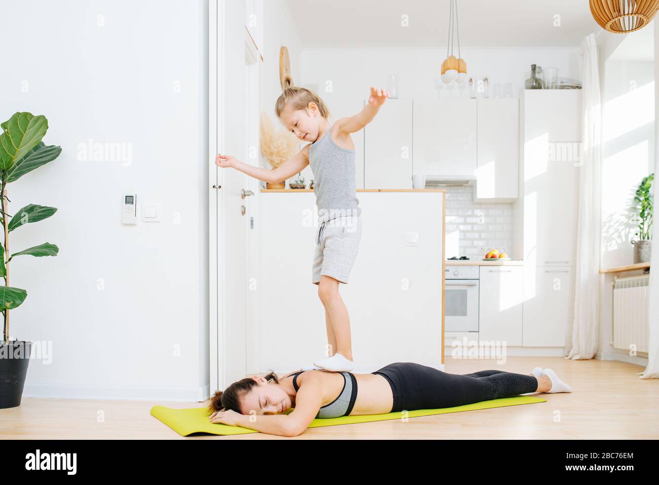 Son walking on mom's back after yoga as pressure massage Stock Photo