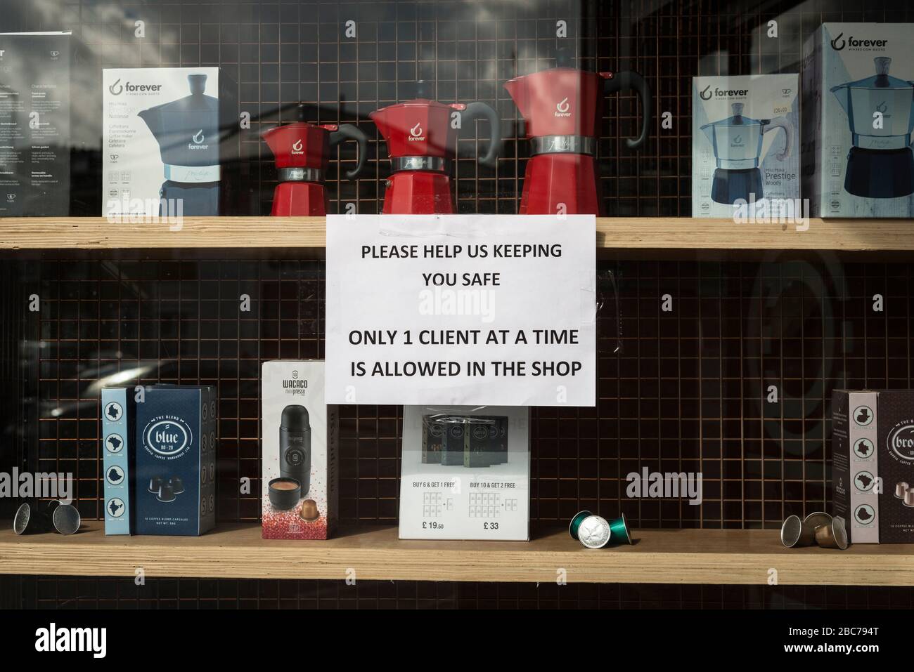 Polite window sign restricting customers outside Doppio coffee shop