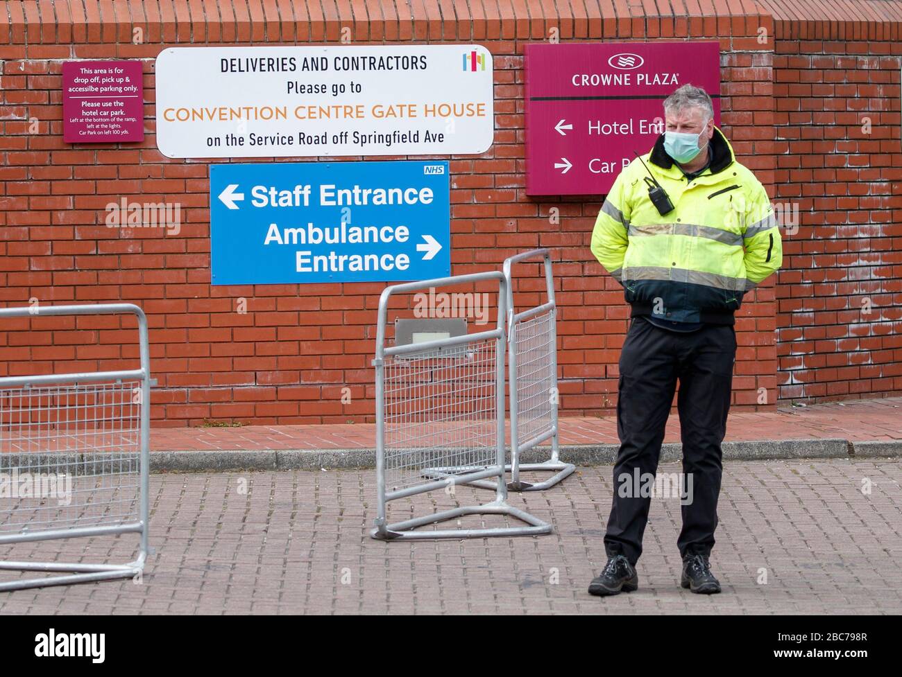 A security guard wearing a facemask outside the Harrogate Convention Centre, that is being converted to take up to 500 patients from Yorkshire and the north-east of England, as the UK continues in lockdown to help curb the spread of the coronavirus. Stock Photo