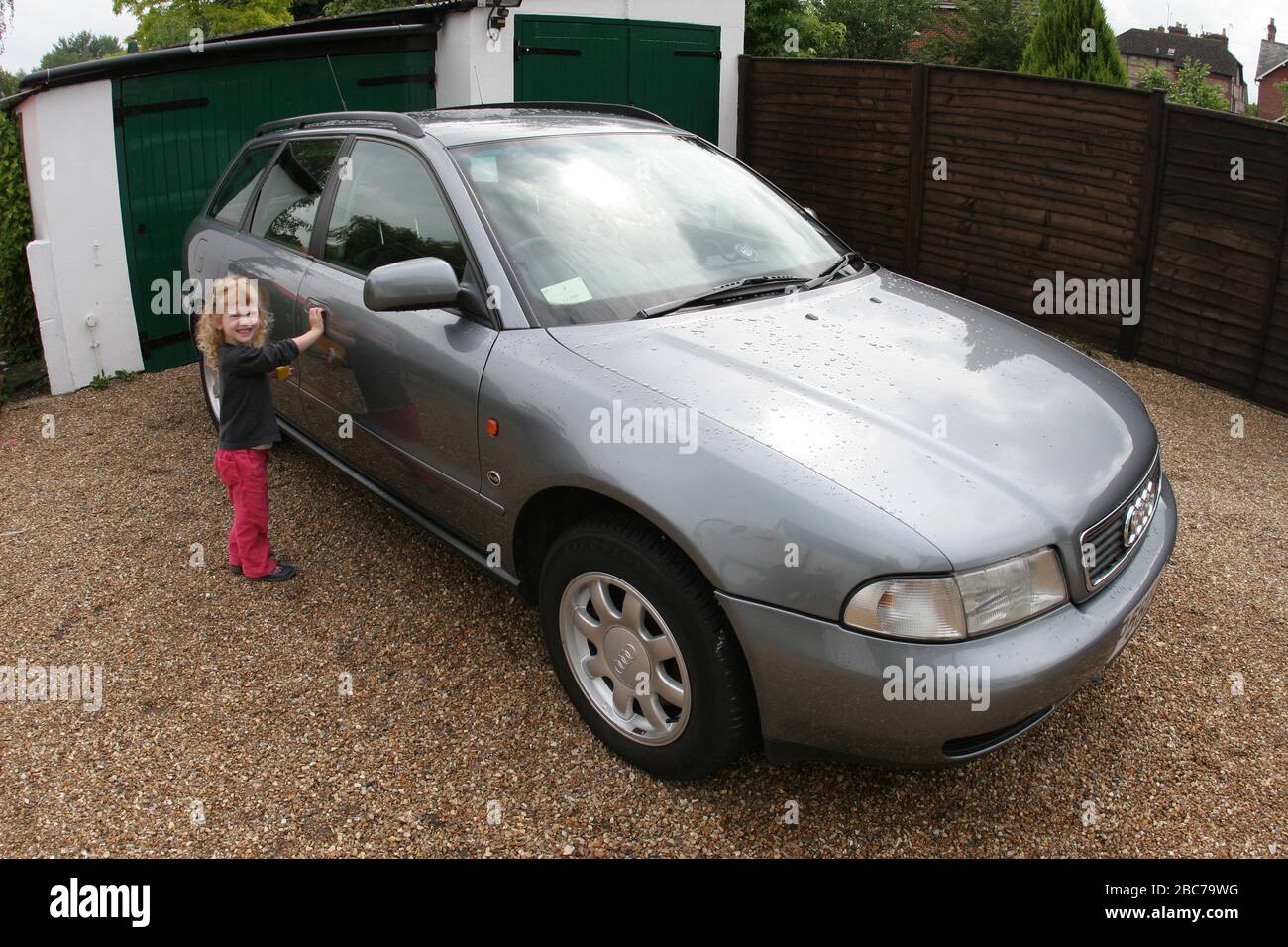 When can I drive the car? A young girl beside the driver's door of the family car - a 1996 Audi A4 Avant. Taken in Salisbury, Wiltshire UK 2005. Stock Photo