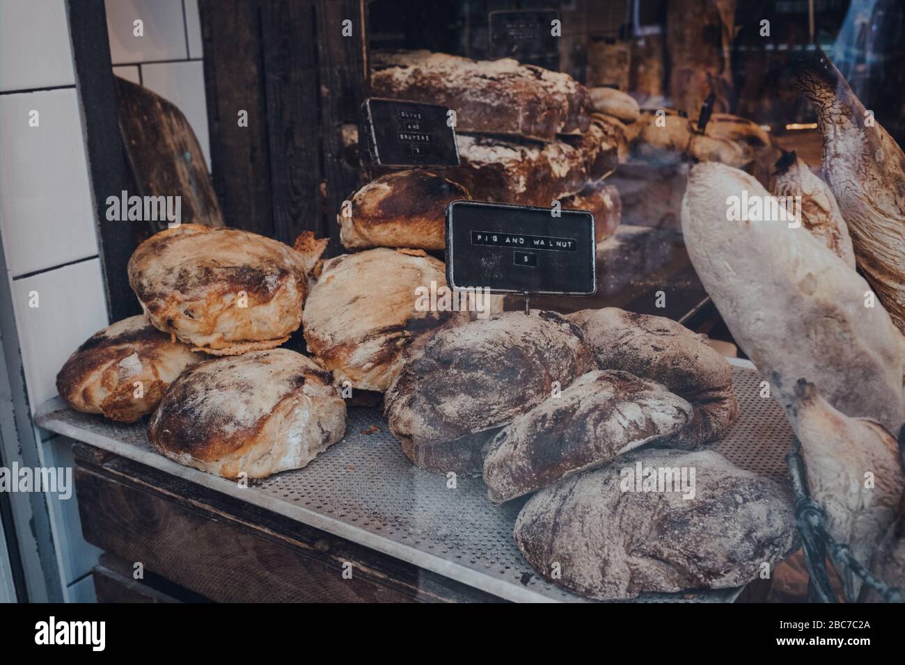 Variety of fresh artisan loaves of bread on a window display of a ...