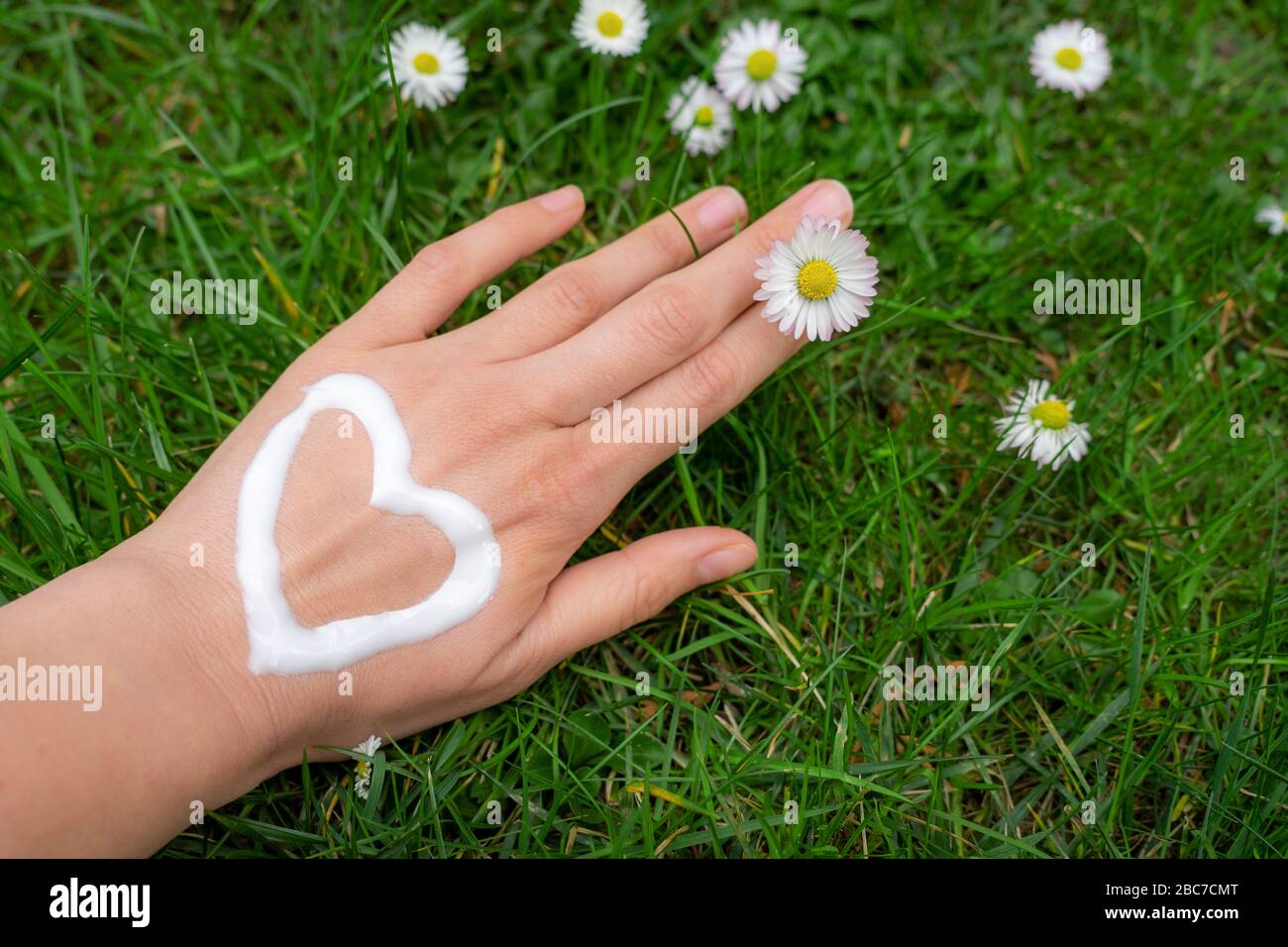 nursing dry hand skin with lotion cream after washing hands so often Stock Photo