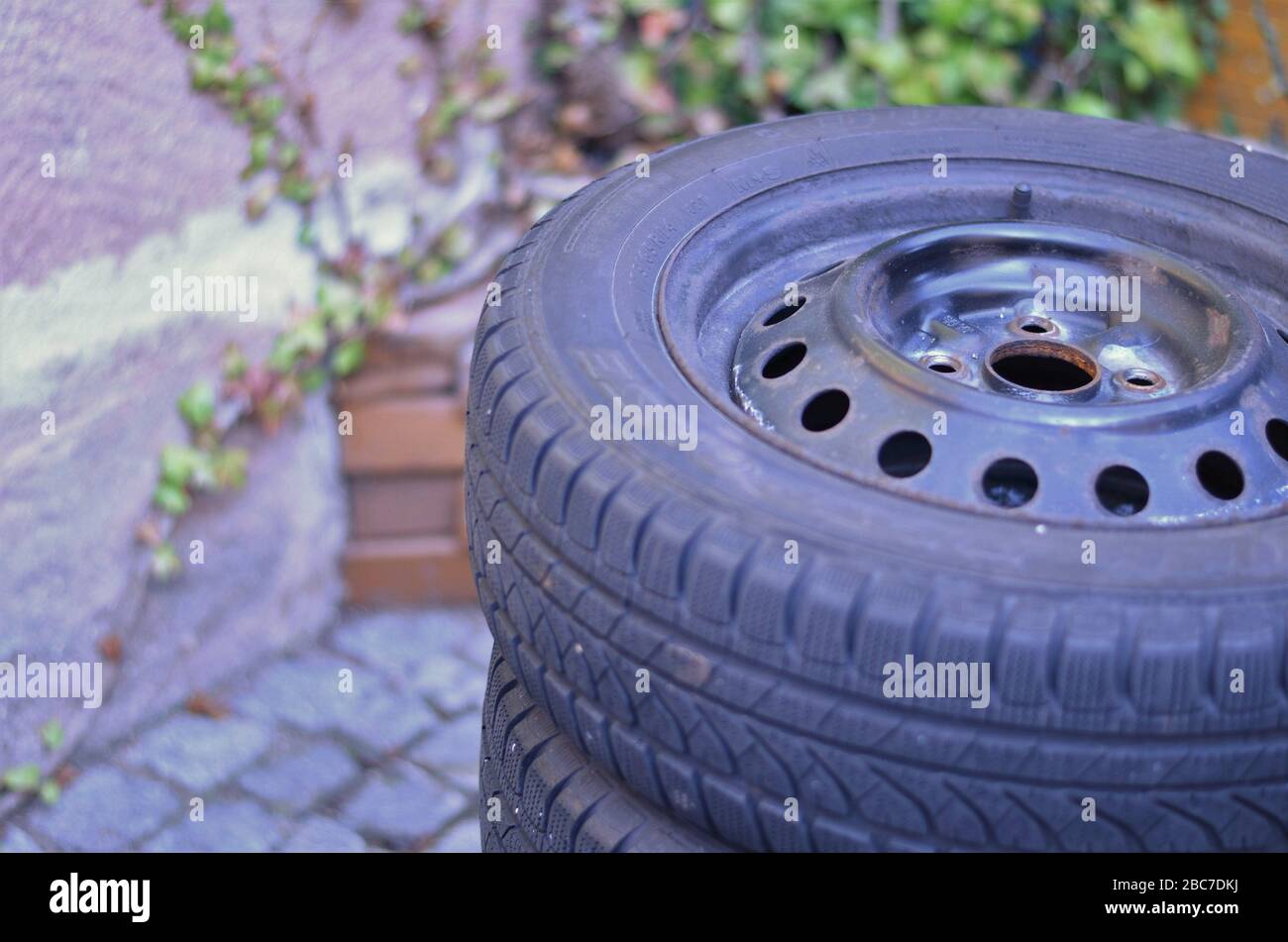 Winter car tires in a small backyard during tire change. Stock Photo